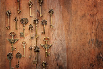 Image of old antique keys over wooden background. Top view, flat lay