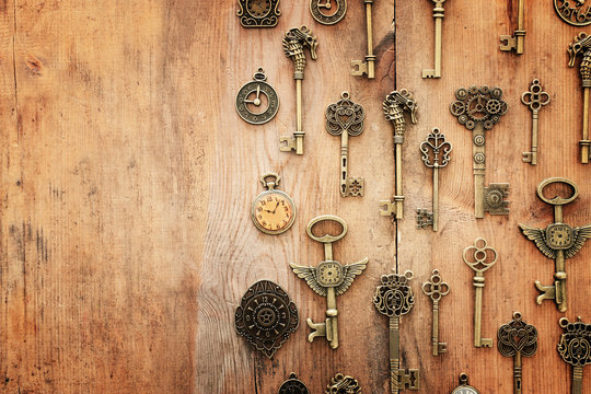 Image of old antique keys and clocks over wooden background. Top view, flat lay