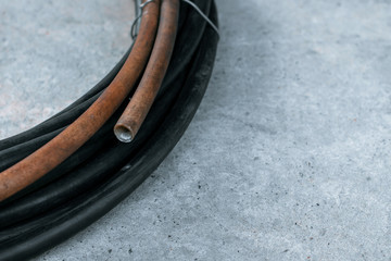 Old rubber hose on the concrete floor. Water hose for gardening