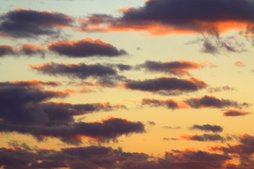 Clouds in the blue sky at sunset or dawn backlit by the sun. Place for text and design.