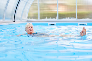 Senior Frau beim Rückenschwimmen im Pool