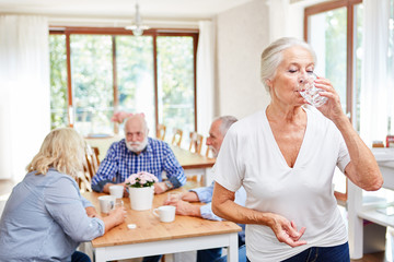 Seniorin nimmt eine Tablette als Medizin