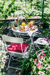 Al fresco mediterranean style breakfast with soft-boiled egg in an eggcup, coffee, juice, croissant and berries