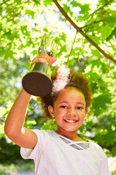 Afrikanisches M&auml;dchen mit Pokal freut sich