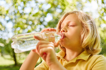 Junge trinkt durstig aus Flasche Mineralwasser
