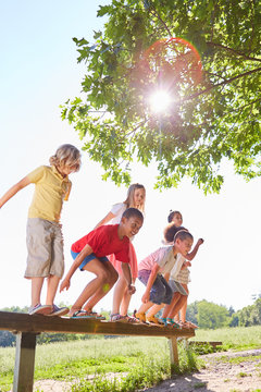 Gruppe Kinder springt von einem Balancierbalken