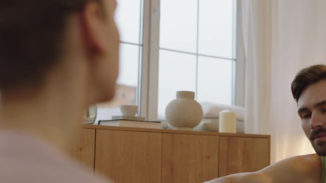 ARC Over the shoulder shot, happy couple having a conversation at home