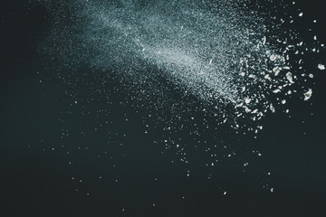 Wonderful pattern of white powder of light snow and flour explodes on black background