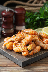 Shrimp on a wooden Board on a brown wooden table. Shrimp shrimps visor. Ecological seafood