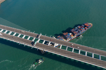 Top view of cargo ship pass though suspension bridge