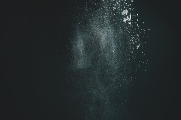 Wonderful pattern of white powder of light snow and flour explodes on black background