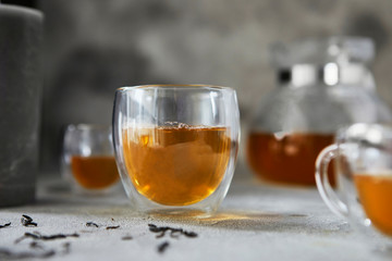 Cups with tea and teapot on a gray background. Close-up. copy space