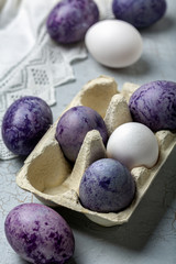 Obraz na płótnie Canvas Stylish blue and purple Easter eggs in a paper tray.
