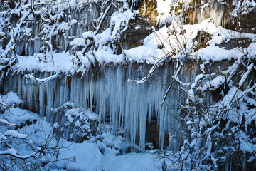 Icicles on the rock. Frozen waterfall in winter.