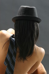 A woman wearing a black hat against a black background