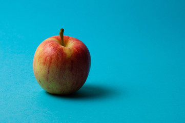 Apple on a blue background. Healthy eating, calorie count and weight loss concept