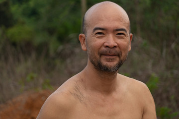Obraz premium funny grinding Japanese beard bald man portrait topless in nature background