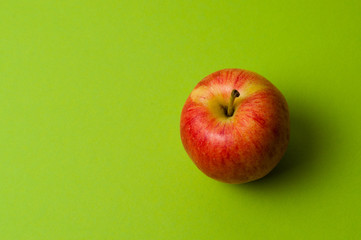 Apple on green background. Healthy eating, calorie count and weight loss concept