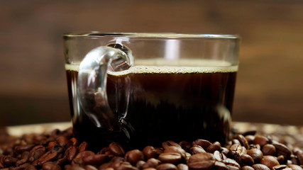 Glass cup of coffee with beans Rotating Rotating on black background. Close up.