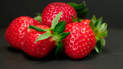 Fresh Strawberry rotating on a black background. Close up.
