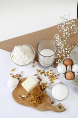Preparation for the preparation of Easter cake or cake, products for the preparation of homemade baking: eggs, butter, raisins, milk, flour on the table