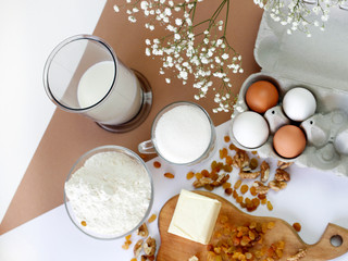 Preparation for the preparation of Easter cake or cake, products for the preparation of homemade baking: eggs, butter, raisins, milk, flour on the table