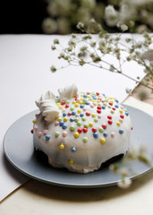 Glazed Easter cake decorated with marshmallows and food decorative elements on the table for the traditional Christian holiday Easter
