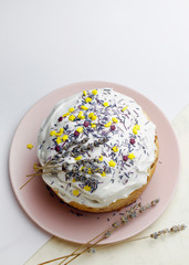 Glazed Easter cake decorated with flowers and food decorative elements on the table for the traditional Christian holiday Easter