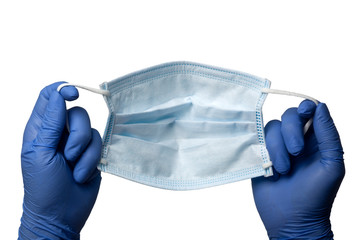 Gloved hands holding a surgical mask