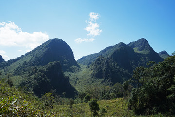 Natural landscape of green mountain range with cloudy blue sky