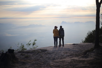 Fototapeta premium Men and women standing on the cliff, waiting for sunrise in Phu Kradueng National Park, Loei, Thailand 