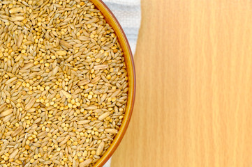 whole grain in a white bowl on wooden background. Healthy breakfast concept.