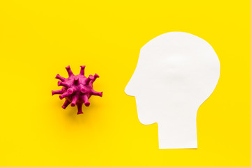 Corona virus Covid-19 - diagnostics concept with strain virus model and human's head - on yellow background top-down