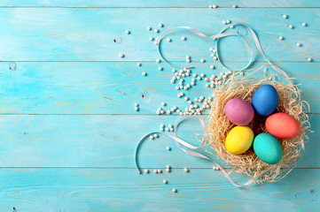 Easter concept. Colorful eggs on blue wooden background with copy space for text. Top down view or flat lay