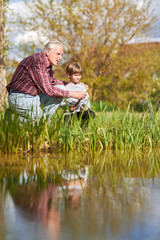 Fototapeta premium Grandpa shows and explains fishing to his grandson