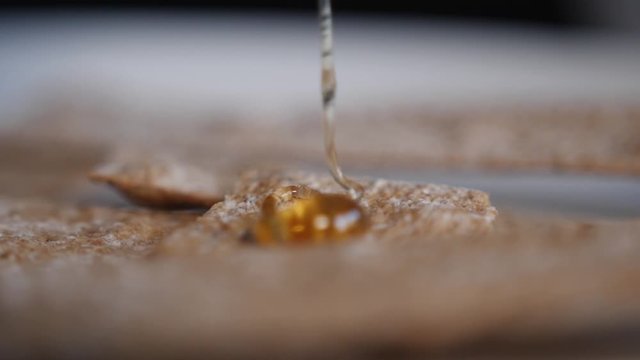 Macro shot of honey being drizzled onto a healthy cereal bar.