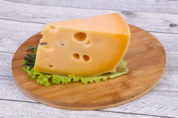 Maasdam cheese  in the board served salad leaves