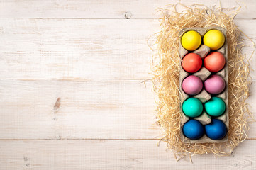 Easter concept. Colorful eggs on white wooden background with copy space for text or design. Top down view or flat lay