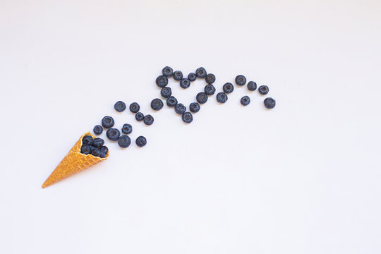 Blueberries and cone waffle on pink background. Be in shape with healthy snacks