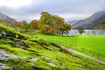 The western shore side of Lake Buttermere in the Lake District showing the path leading down to the...