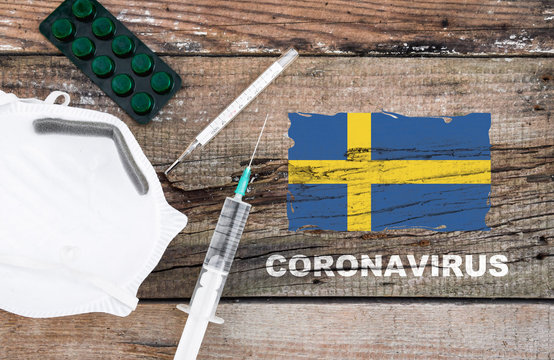 Coronavirus in Sweden. Flag of Sweden, vaccine, face mask for virus, thermometer, and medicals on wooden table with word coronavirus