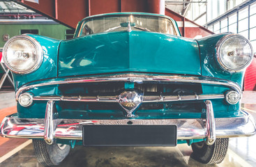 Fototapeta premium Blue and white shiny retro vintage car front view
