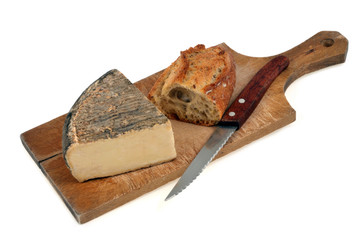 Tomme avec du pain et un couteau sur une planche à découper