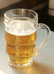 Full mug with beer on the table close-up