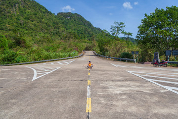 The concept of infinity and loneliness - a woman sits on the road on the dividing strip