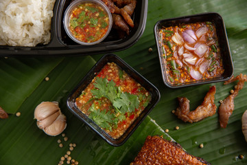 Spicy sauce for eating with sticky rice, fried pork on a banana leaf.