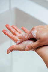 Close-up of woman rubbing hands with a soap.