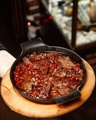lamb stew with onion and pomegranate seed in cast iron pan