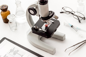 Laboratory examination with microscope. Equipment with blood sample on white background