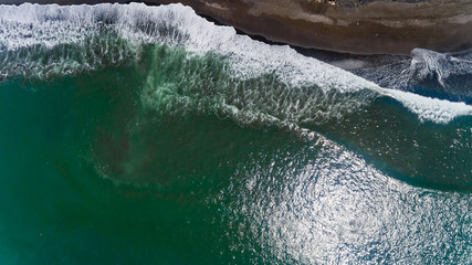 Obraz na płótnie Canvas Top view of wave and black sand.